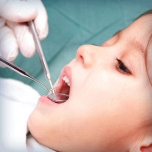 child being examined by a dentist